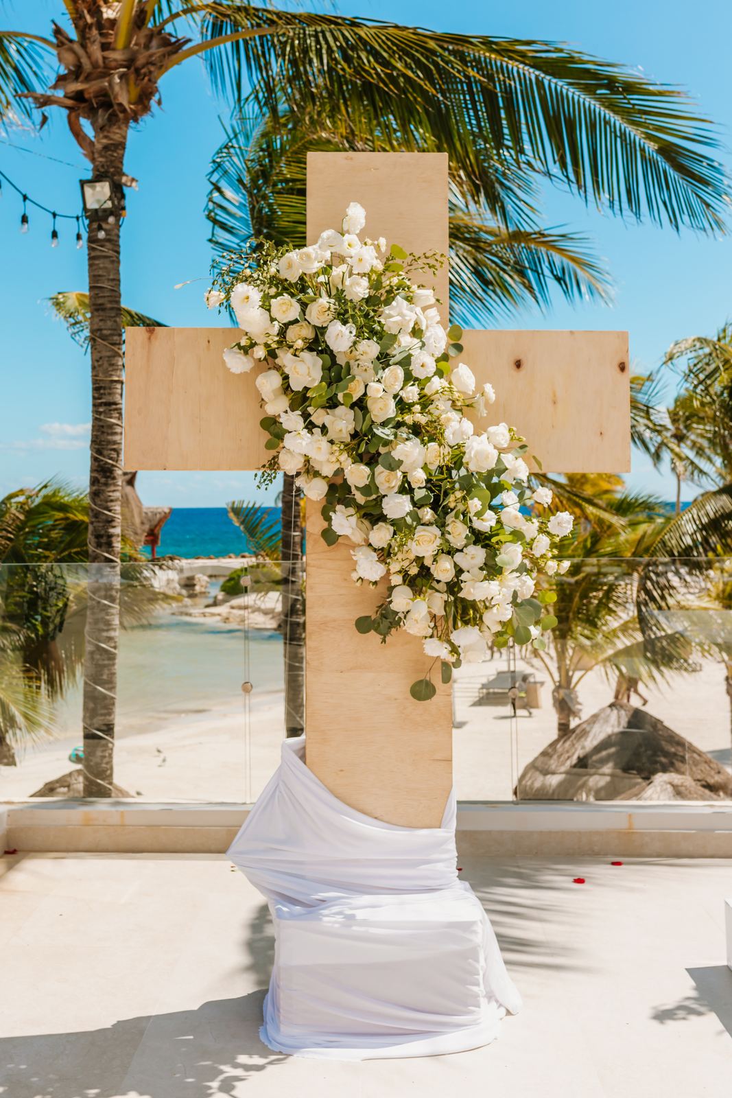 A wooden cross dressed in white roses on the ceremony terrace
