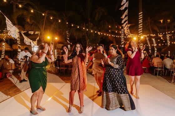 Guests dancing on the white floor under strings of lights