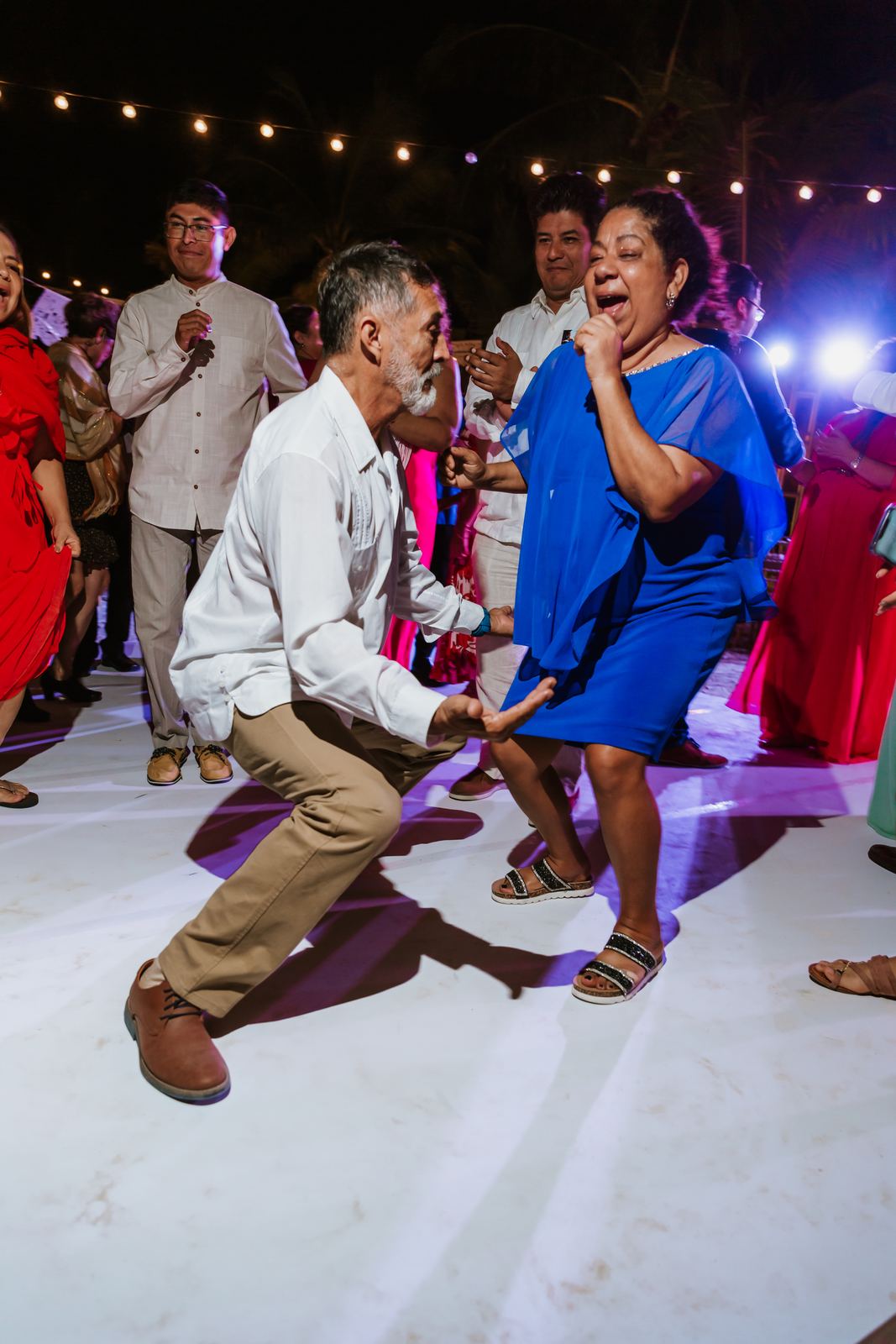 Two guests dancing low on the floor under the lights