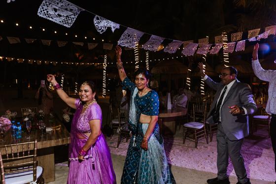 Guests dancing beneath papel picado and festoon lights